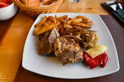 Pečena teletina s krompirom servirana na tanjiru u restoranu.