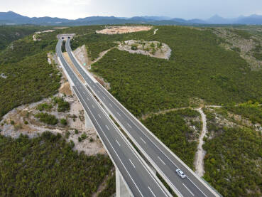 Vozila se kreću po visokom mostu na autoputu, snimak dronom. Saobraćaj na modernom vijaduktu na autoputu.