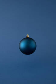Plava božićna kuglica na plavoj pozadini.