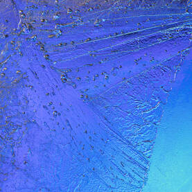 Smrznute kapljice na staklu s plavom pozadinom