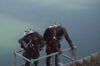 Dva ronioca se spuštaju u korpi, niz betonsku podlogu, do vode.