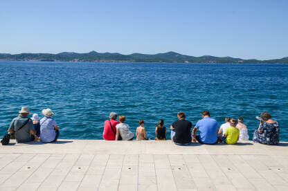 Grupa turista na odmoru. Ljudi uz more.
