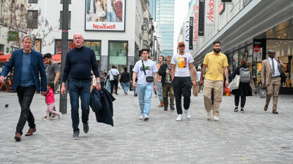 Brisel, Belgija: Grupa ljudi šeta šetalištem. Ljudi svih generacija u Briselu. Raznolikost Brisela.