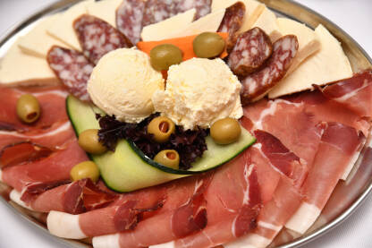 Meza servirana na tanjiru. Sir, kajmak, suva kobasica i pršut.