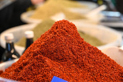 Crveni čili u prahu na prodaju na pijaci. Mljevena crvena čili papričica začin na lokalnom štandu.