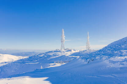 Smrznuti TV ili mobilni toranj prekriven  velikim snijegom. Telekomunikacijski tornjevi s antenom i mobilnom antenom. Planina Vlašić