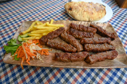 Ćevapi ili ćevapčići. Tradicionalno mesno jelo na Balkanu. Meso pripremljeno na roštilju i servirano uz somun i povrće. Ćevapi u Skoplju, Sjeverna Makedonija.