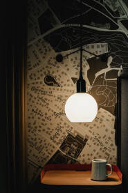 Detalji enterijera hotelske sobe. Lampa koja obasjava mapu grada Budimpešte i šoljicu kafe.