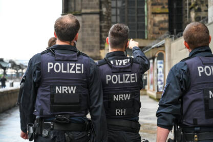 Specijalne policijske snage Njemačke. Policajci u uniformi patroliraju gradom. Grupa policajaca u gradu.