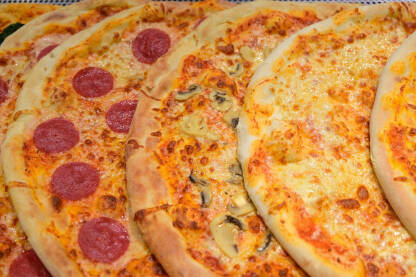 Ukusne pizza servirane u restoranu. Brza hrana. Mnogo različitih vrsta italijanskih pica na stolu.