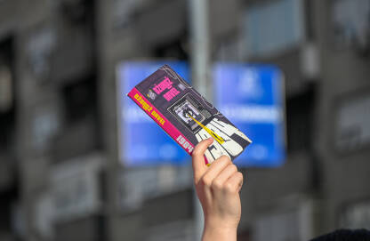 Studenstki protesti u Srbiji Knjiga Džordža Orvela 1984. Ženska ruka drži visoko podignutu knjigu 1984 na studentskim blokadama u Beogradu. Bunt protiv autokratije.