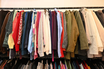 Odjeća na prodaji u trgovini. Odjeća visi na vješalici u radnji.  Bluze, majice, haljine i džemperi.