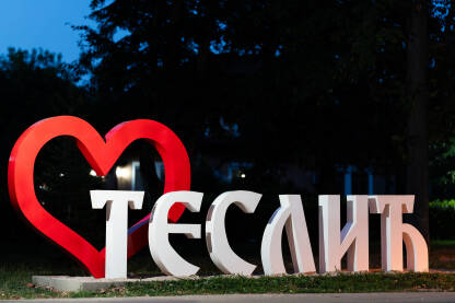 Znak Teslić u gradskom parku.
Crveno srce u pozadini, noćna fotografija.