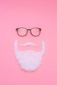 Muškarac sa crnim naočalama, biijelim brkovima i bradom na roze, pink podlozi, hipster, koncept