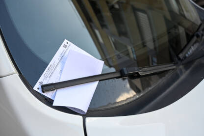 Obavještenje o prekršaju parkiranja na vjetrobranskom staklu automobila. Kazna za parkiranje postavljena na vjetrobransko staklo vozila. Vozilo u prekršaju.