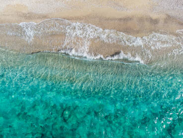 More i valovi. Snimci dronom na valove koji se razbijaju na tropskoj plaži sa pijeskom. Obala. Prekrasna pješčana plaža ljeti.