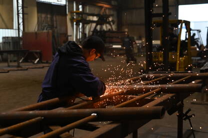 Radnik koristi brusilicu u metalnoj industriji