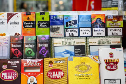 Kutije cigareta na policama u trgovini. Kutije cigareta na policama u trgovini. Polica za cigarete u prodavnici. Paketi cigareta sa upozorenjima. Duhan. Natpisi: Pušenje ubija.