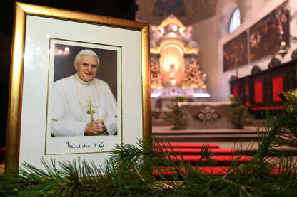 Fotografija pape Benedikta XVI izložena u crkvi nakon njegove smrti. Papa Benedikt XVI bio je poglavar Katoličke crkve. Joseph Aloisius Ratzinger.