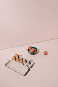 Svježa jaja u kartonskoj kutiji i keramičkoj posudi. Pozadina ili čestitka za Uskrs / Vaskrs.