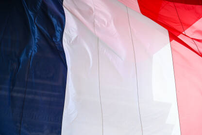 Zastava Francuske se vijori na vjetru. Francuska zastava na Trijumfalnoj kapiji u Parizu. Nacionalna zastava Francuske.
​
