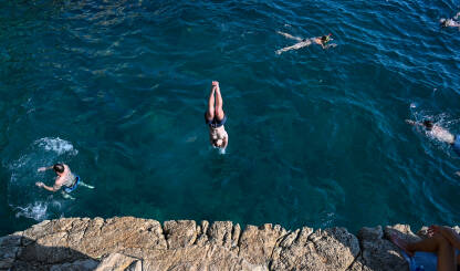 Momak skače u vodu. Turisti u moru. Ljetni godišnji odmor.