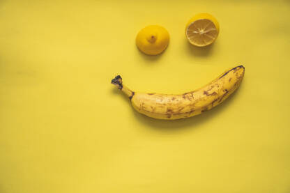 Banana i limun na žutoj pozadini u obliku osmjeha