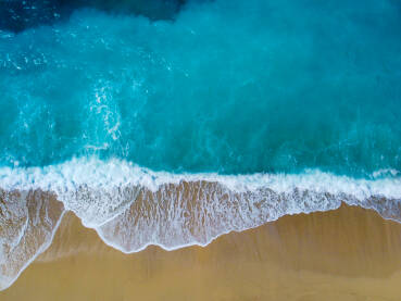 Prekrasna tropska plaža sa žutim pijeskom. Morski valovi na pijesku uz obalu, snimci dronom. Obala mora. Pješčana plaža ljeti.