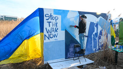 Umjetnik oslikava antiratne poruke. Podrška Ukrajini. Natpis: "Stop the war". Poljsko-ukrajinska granica.