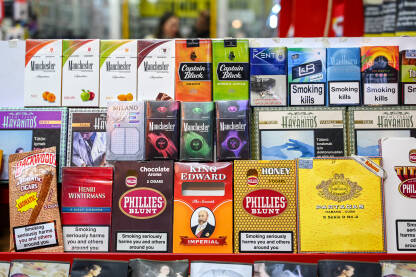 Kutije cigareta na policama u trgovini. Kutije cigareta na policama u trgovini. Polica za cigarete u prodavnici. Paketi cigareta sa upozorenjima. Duhan. Natpisi: Pušenje ubija.