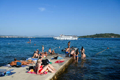 Kupači na moru tokom turističke sezone. Jadransko more. Ljetni odmor. Turisti.
