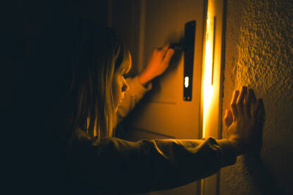 Djevojčica proviruje iz tamne prostorije kroz ključaonicu ka svjetlu