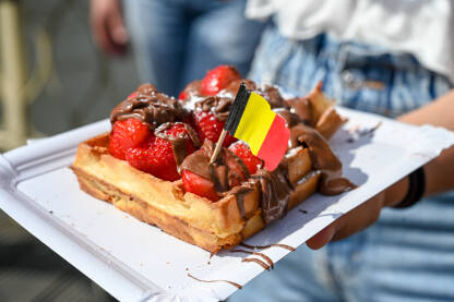 Vafli sa zastavom Belgije. Ukusni kolač sa čokoladnom kremom i jagodama u Briselu.