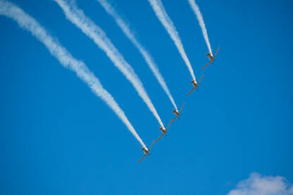 Avioni na plavom nebu tokom aeromitinga. Pet aviona u formaciji.