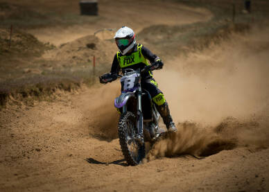 Vozač cross motora tokom trke. Motocross trka. Takmičenje u vožnji cross motora.