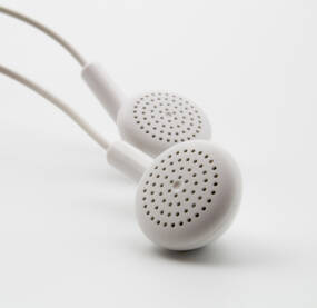 Bele slušalice za uši, fotografisane na beloj pozadini. Mogu se koristiti za telefon, računar, lap-top...