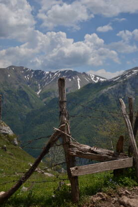 Bosna i Hercegovina, Lukomir. Žičana ograda, zelenilo, planine, nebo.