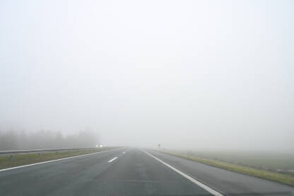 Magla. Vožnja automobila po maglovitom vremenu. Teški uslovi vožnje. Pogled na cestu kroz vjetrobransko staklo automobila. Pogled vozača.