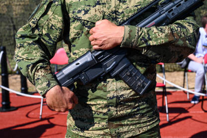 Vojnik u uniformi drži automatsku pušku. Specijalne snage sa oružjem.