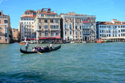 Venecija, Italija: Historijske građevine uz more. Popularna turistička destinacija. Gondola na vodi. Turisti istražuju grad.