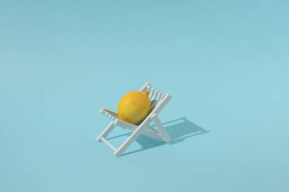 Svježi limun u ležaljci za plažu na plavoj pozadini.