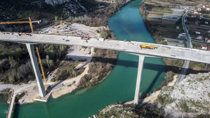 Izgradnja visokog mosta preko rijeke, snimak dronom iz zraka. Radnici i mašine na gradilištu. Most na autoputu. Most preko Neretve kod Počitelja. Autoput Vc.