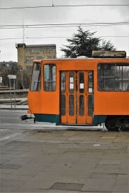 Један део трамваја је наранџасте боје, врата и прозори трамваја, доњи део трамваја је плаве боје.