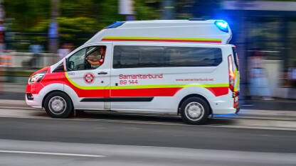 Zamagljeni automobil hitne pomoći koji se brzo kreće ulicom u Beču. Hitna pomoć u gradu.