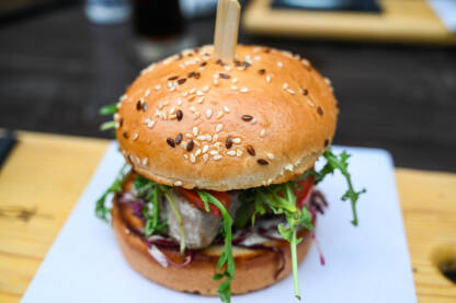 Ukusan fishburger poslužen na stolu u restoranu. Odrezak od tune.