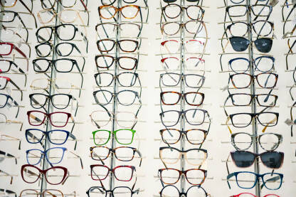 Naočale izložene u optičarskoj trgovini. Veliki broj naočala i sunčanih naočala u izlogu.