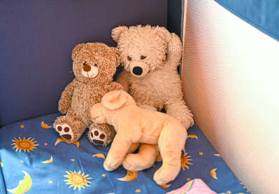 Medvjedić i druge lutke u dječjem krevetu. Kolekcija igračaka u sobi za bebe.
