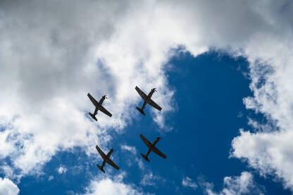 Grupa aviona koji lete u formaciji na aeromitingu. Četiri aviona lete u akrobatskoj formaciji.