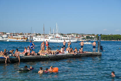 Kupači na moru tokom turističke sezone. Jadransko more. Ljetni praznici. Turisti.