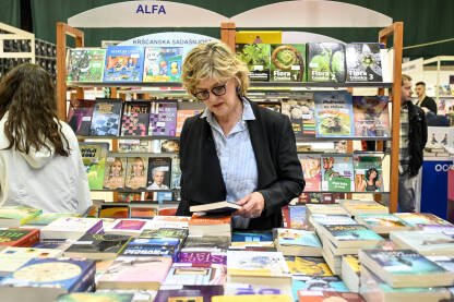 Sarajevski sajam knjige. Ljudi pregledavaju naslove knjiga. Kolekcija knjiga na sajmu.